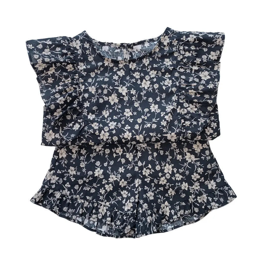 Black floral two-piece outfit laid flat, showing the ruffled top and matching shorts
