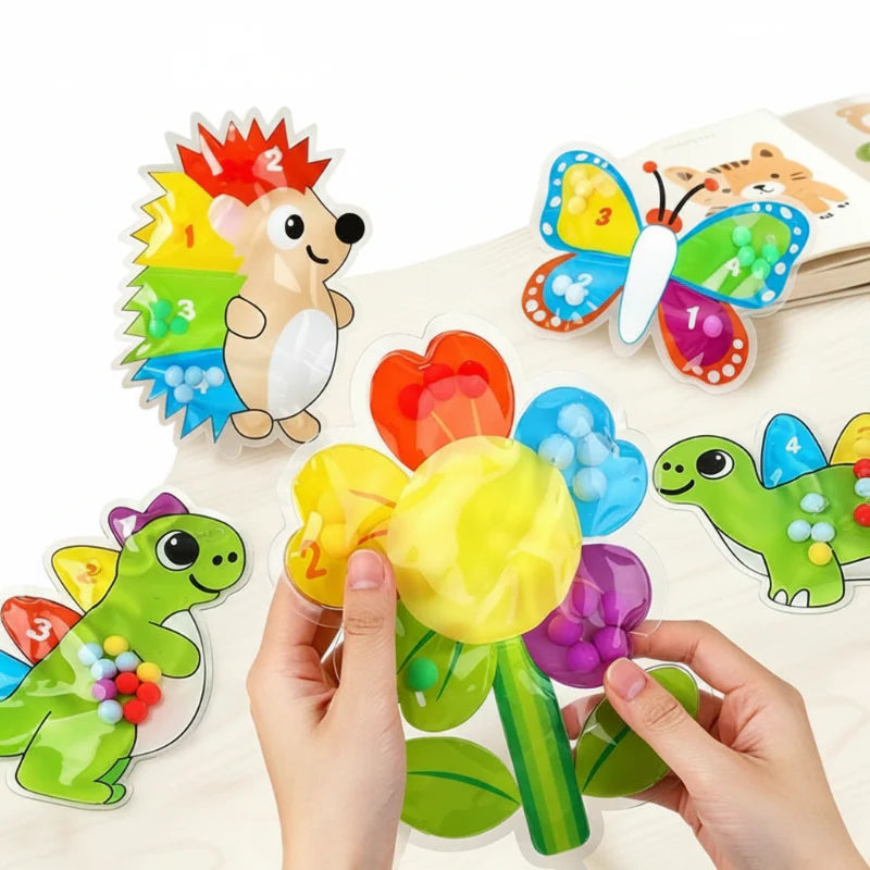 Hands pressing a flower bead maze with animal and butterfly designs nearby