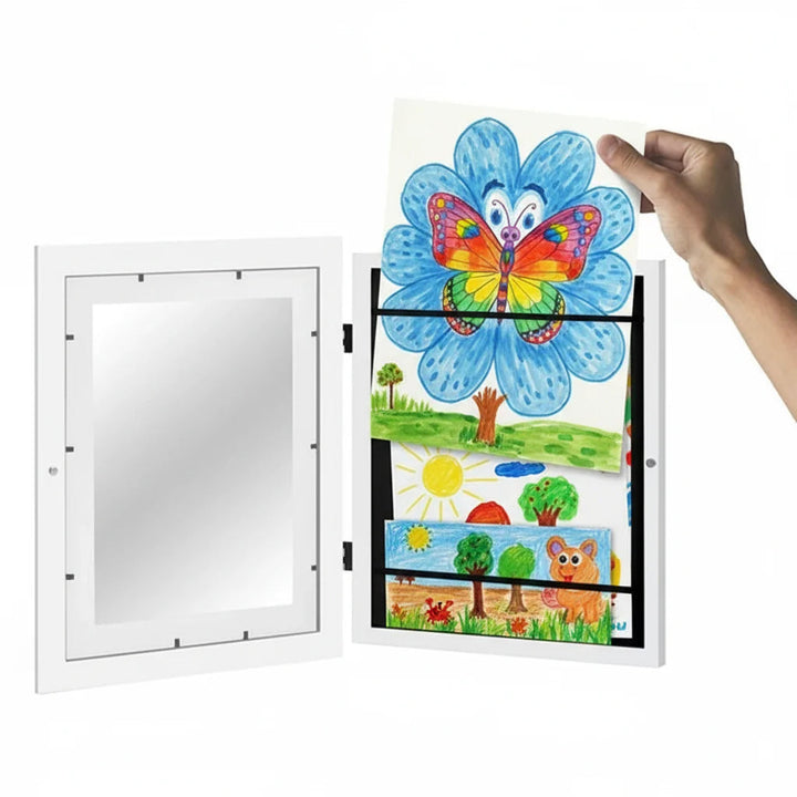 Hand changing a flower drawing in an open white art frame