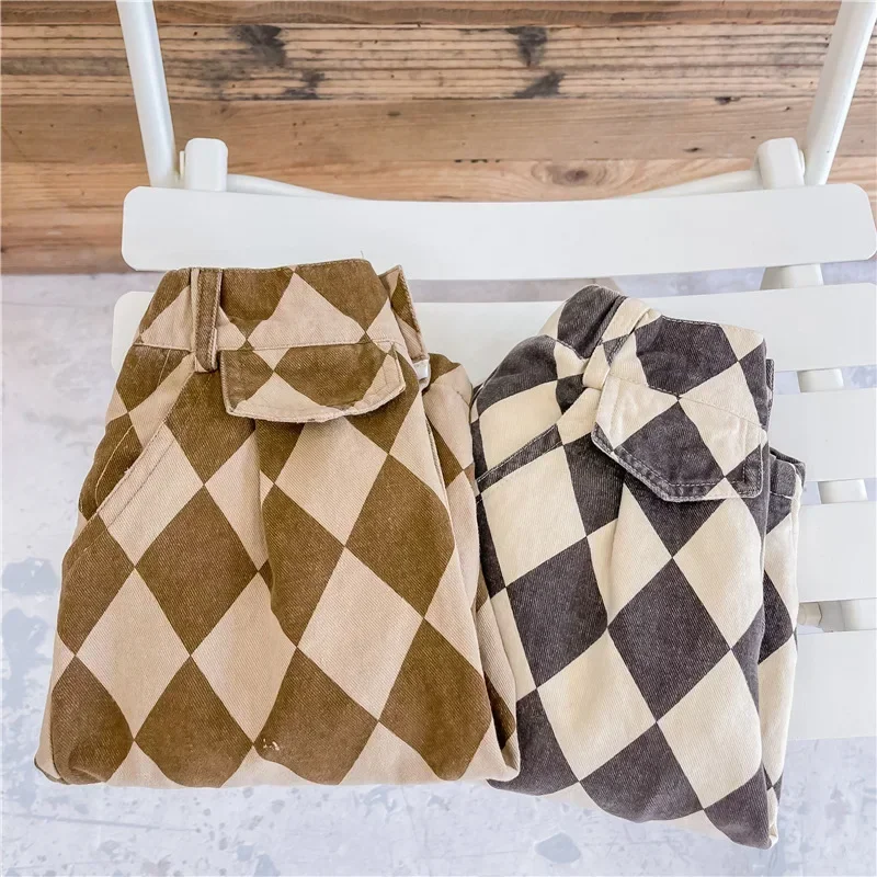 Folded brown and gray argyle pants on a white chair, showing pocket flap details