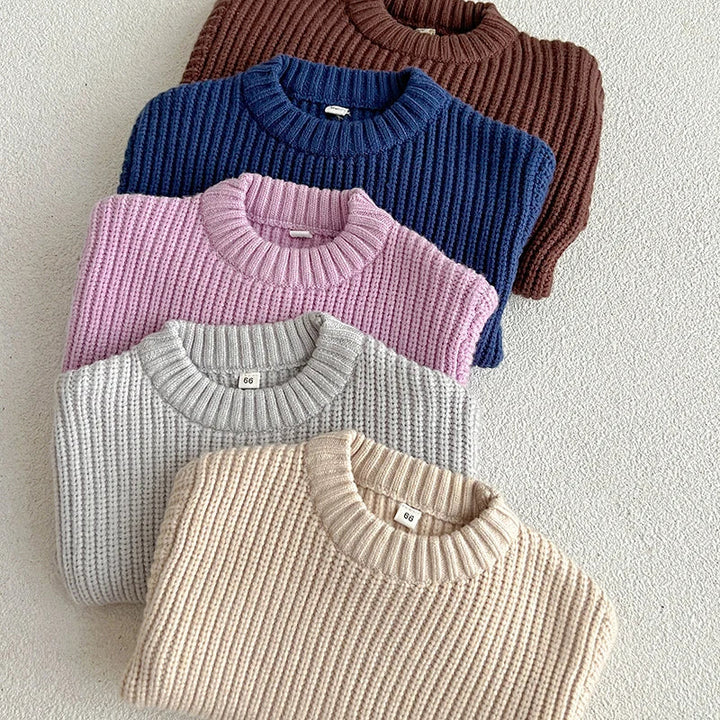 Folded cotton knit sweaters in apricot, gray, purple, dark blue, and brown.