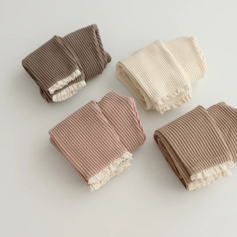 Four colors of ribbed cotton leggings folded to show their lace-trimmed cuffs.