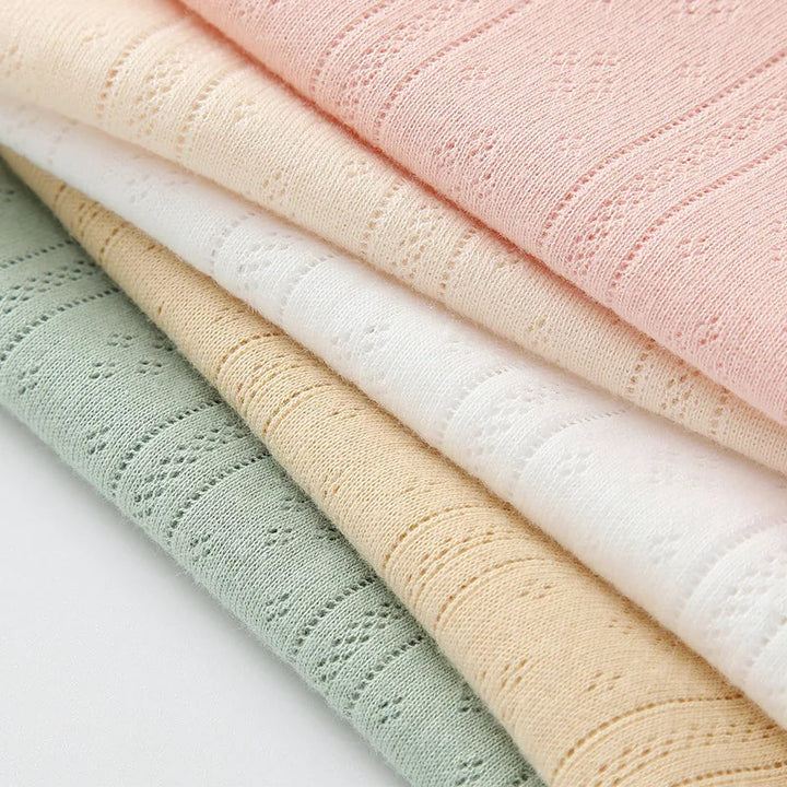 Folded pastel cotton fabrics showing the bodysuits&