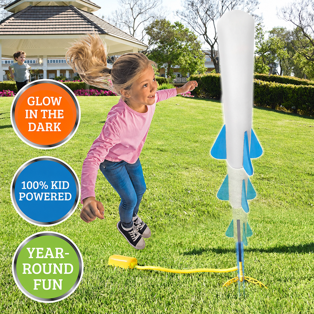 Child jumping beside a foot-powered rocket launcher on a lawn.