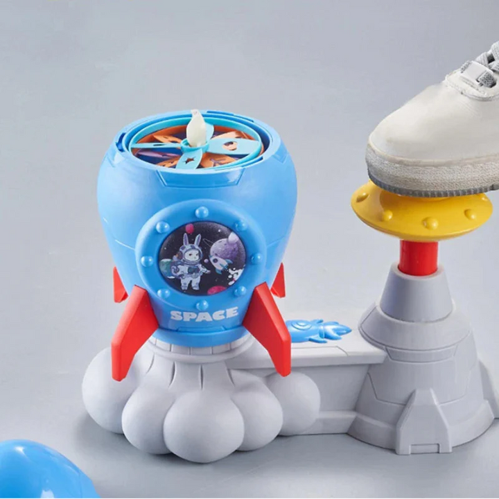 A shoe pressing the yellow pedal on a blue rocket launcher loaded with colorful discs
