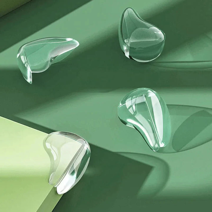 Four transparent corner covers arranged on a green surface