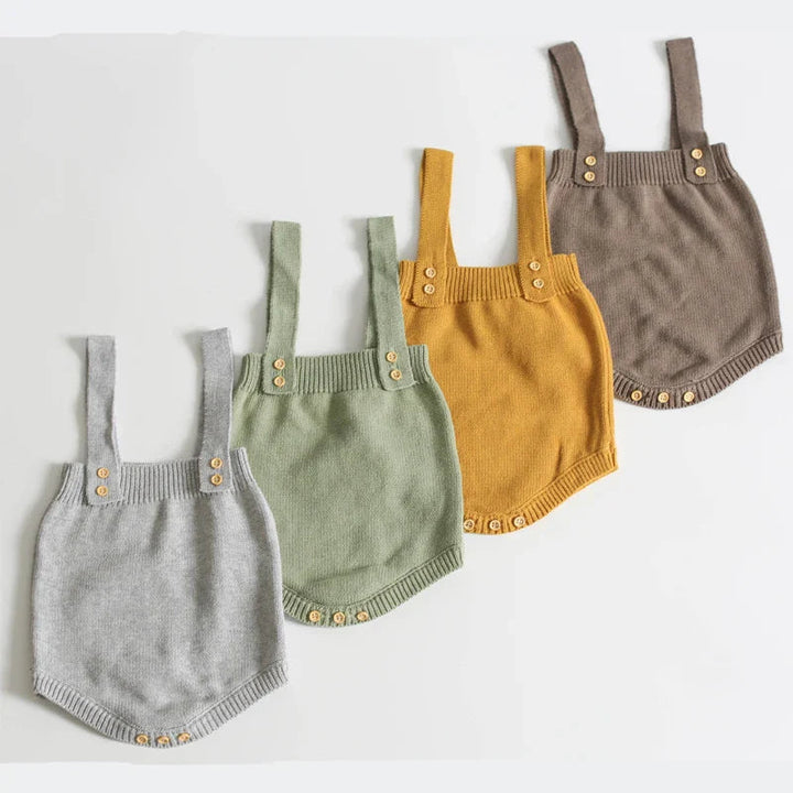 Gray, green, mustard yellow, and taupe baby rompers arranged to show their buttoned straps