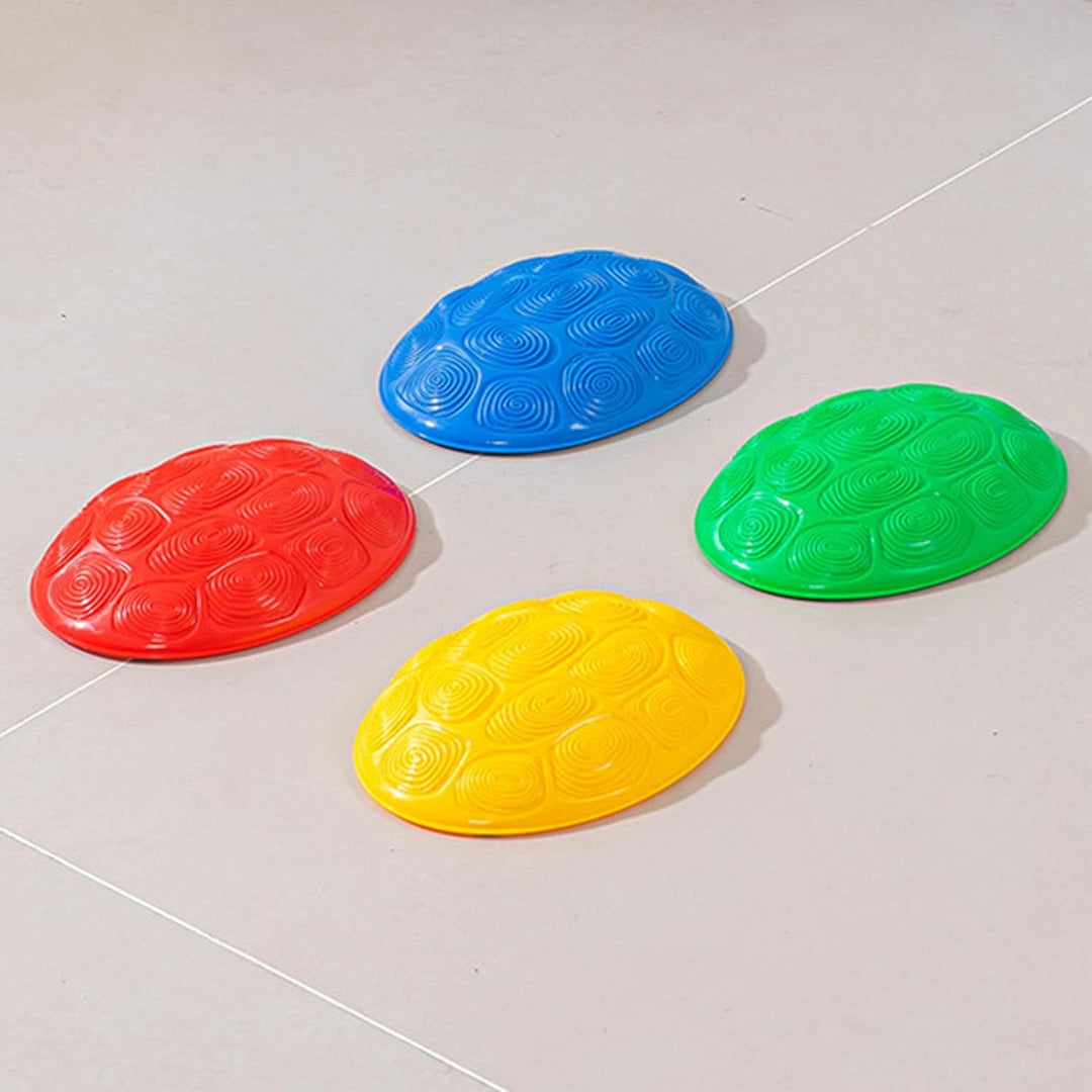 Four shell-pattern stepping stones in red, blue, green, and yellow on a tiled floor