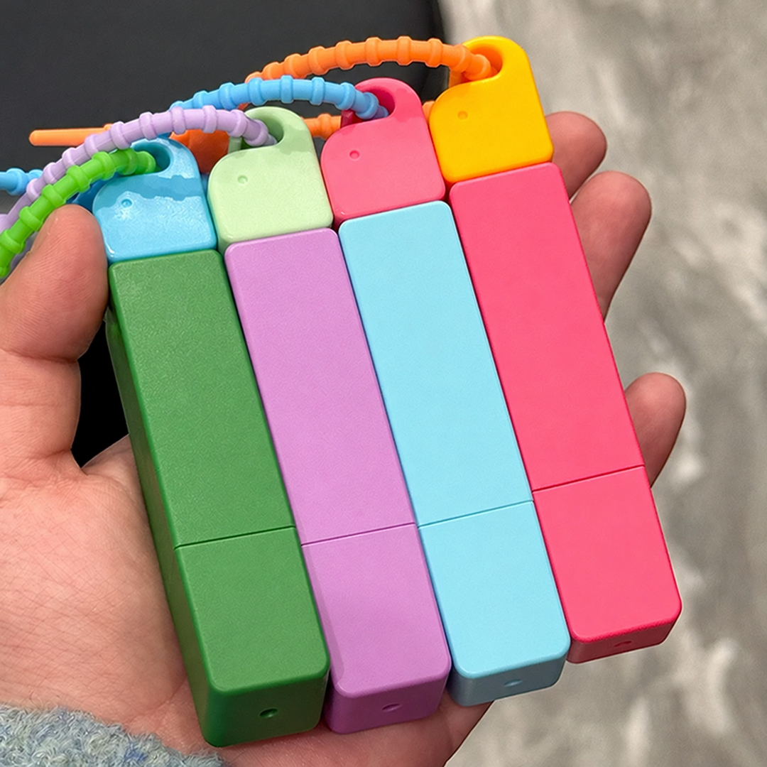 Four colorful stain remover pens with loop straps held in one hand