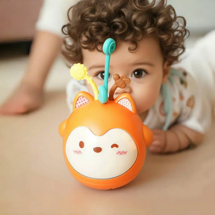 Baby looking at the orange fox night light with three colorful pull strips.