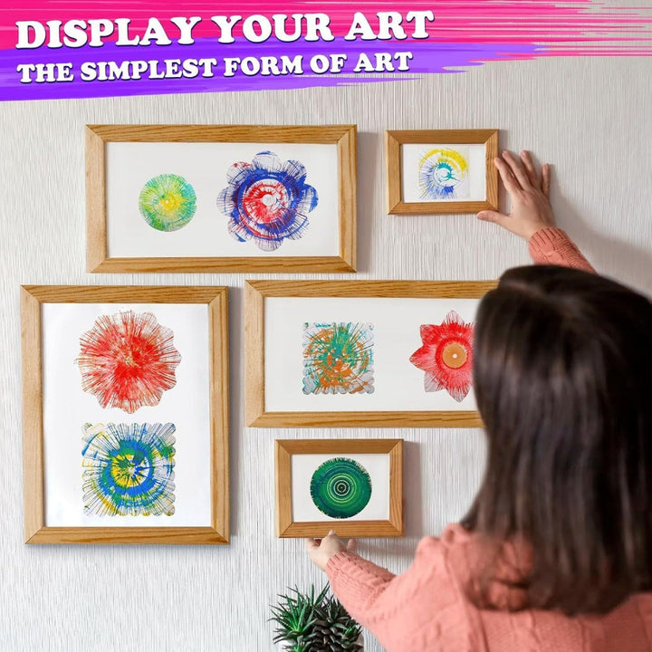 Finished spin paintings displayed in wooden frames on a wall