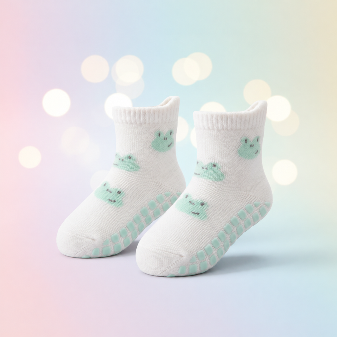 White frog-pattern baby socks with mint-colored grip dots and ribbed cuffs.