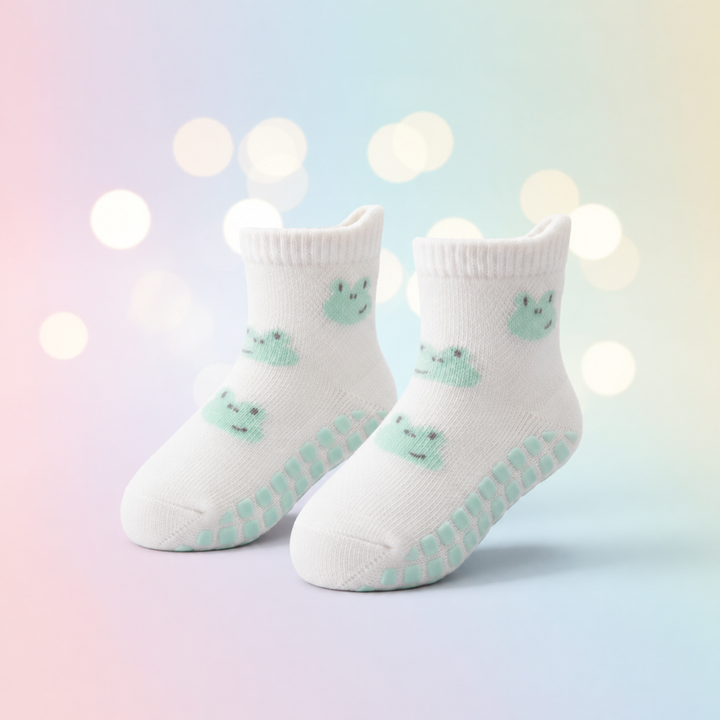 White frog-pattern baby socks with mint-colored grip dots and ribbed cuffs.