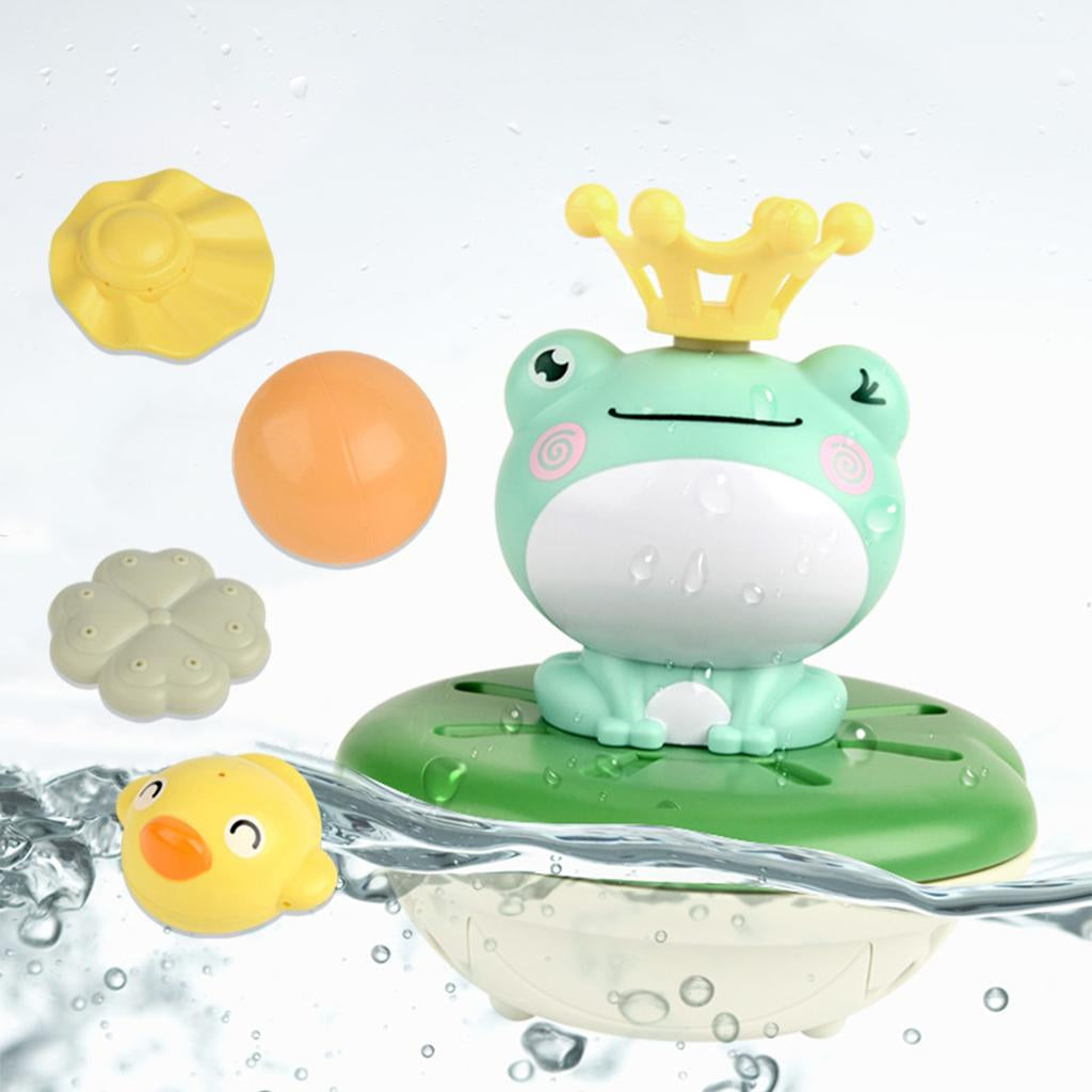 Frog bath fountain at the waterline, wearing a yellow crown beside colorful toppers