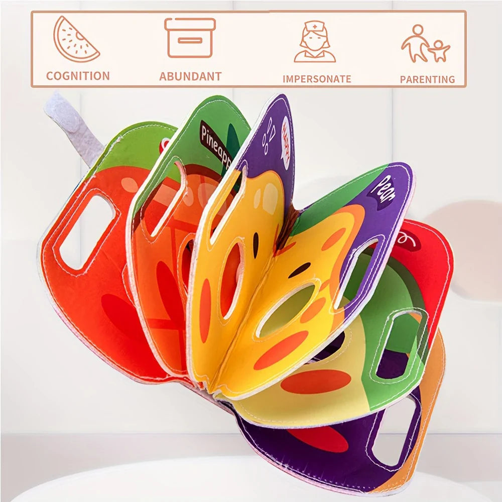 Fruit-themed cloth book opened to show colorful face cutouts and side hand openings.