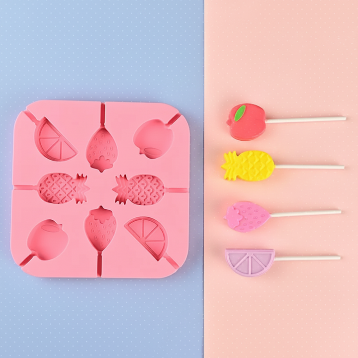 Pink fruit lollipop mold with apple, pineapple, strawberry, and citrus-shaped treats