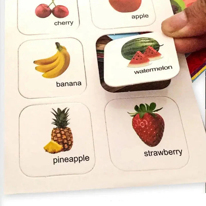 Hand lifting a watermelon matching piece from a labeled fruit activity page