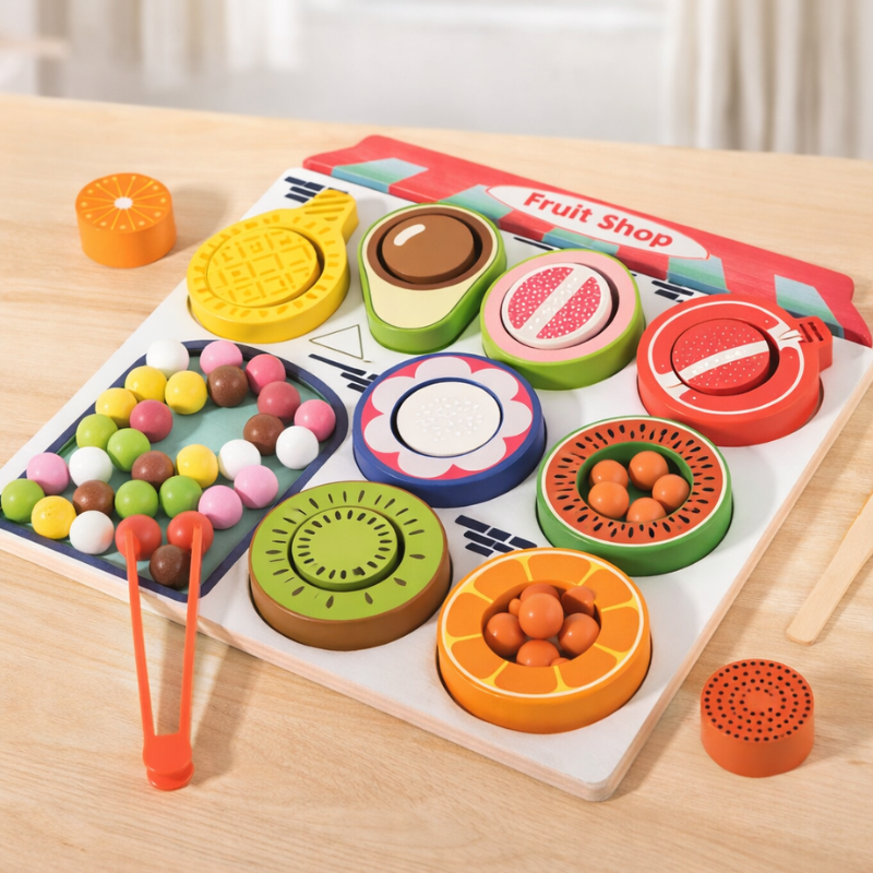 Extended fruit sorting board with removable bowls, colorful balls, and red tongs on a table