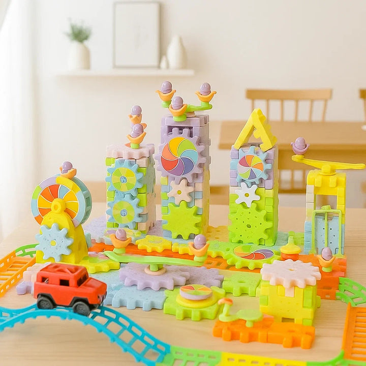 Gear block playground with towers, large gears, and an orange toy car on blue and yellow track sections.