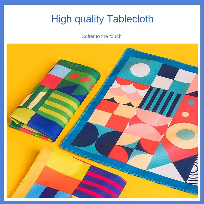 Patterned fabric mats shown folded and laid flat, with bright geometric shapes and blue edging