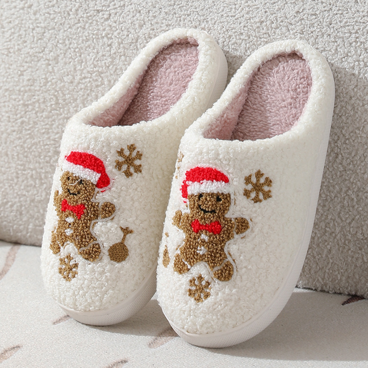 Gingerbread character slippers with red Santa hats, bow ties and snowflake motifs.