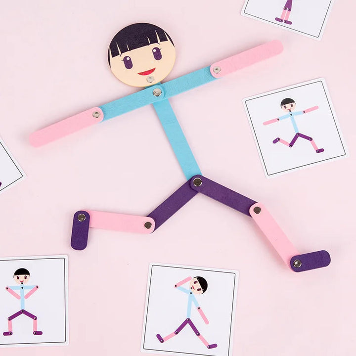 Girl-style jointed figure with outstretched arms and pose cards on a pink background