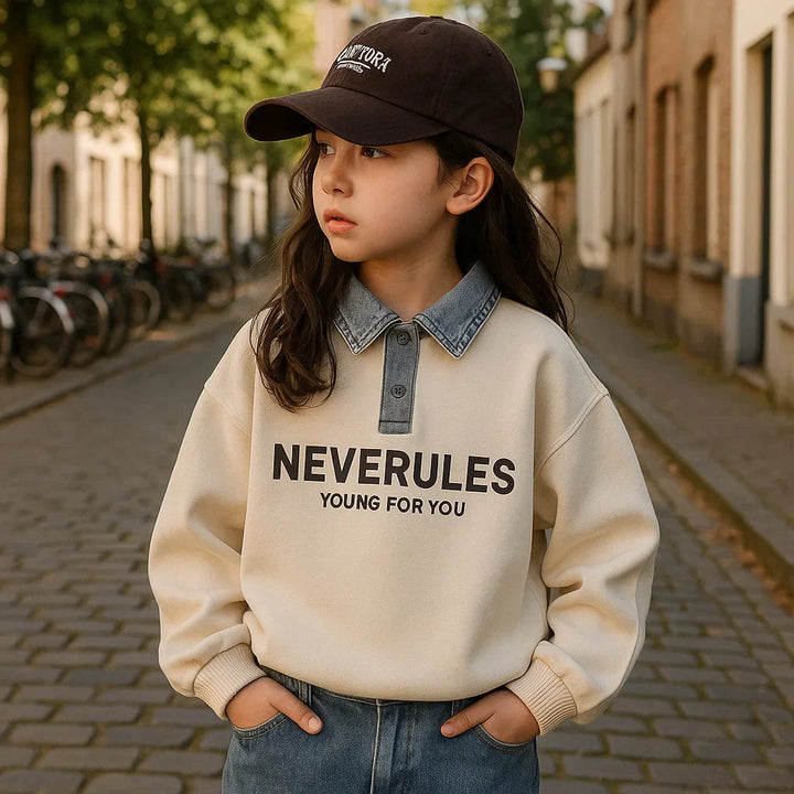 Girl wearing a cream denim-collar polo with jeans and a dark cap outdoors