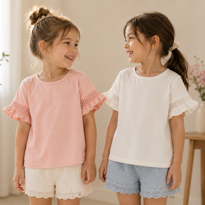 Two girls wearing pink and white cotton tops with lace-trimmed bell sleeves