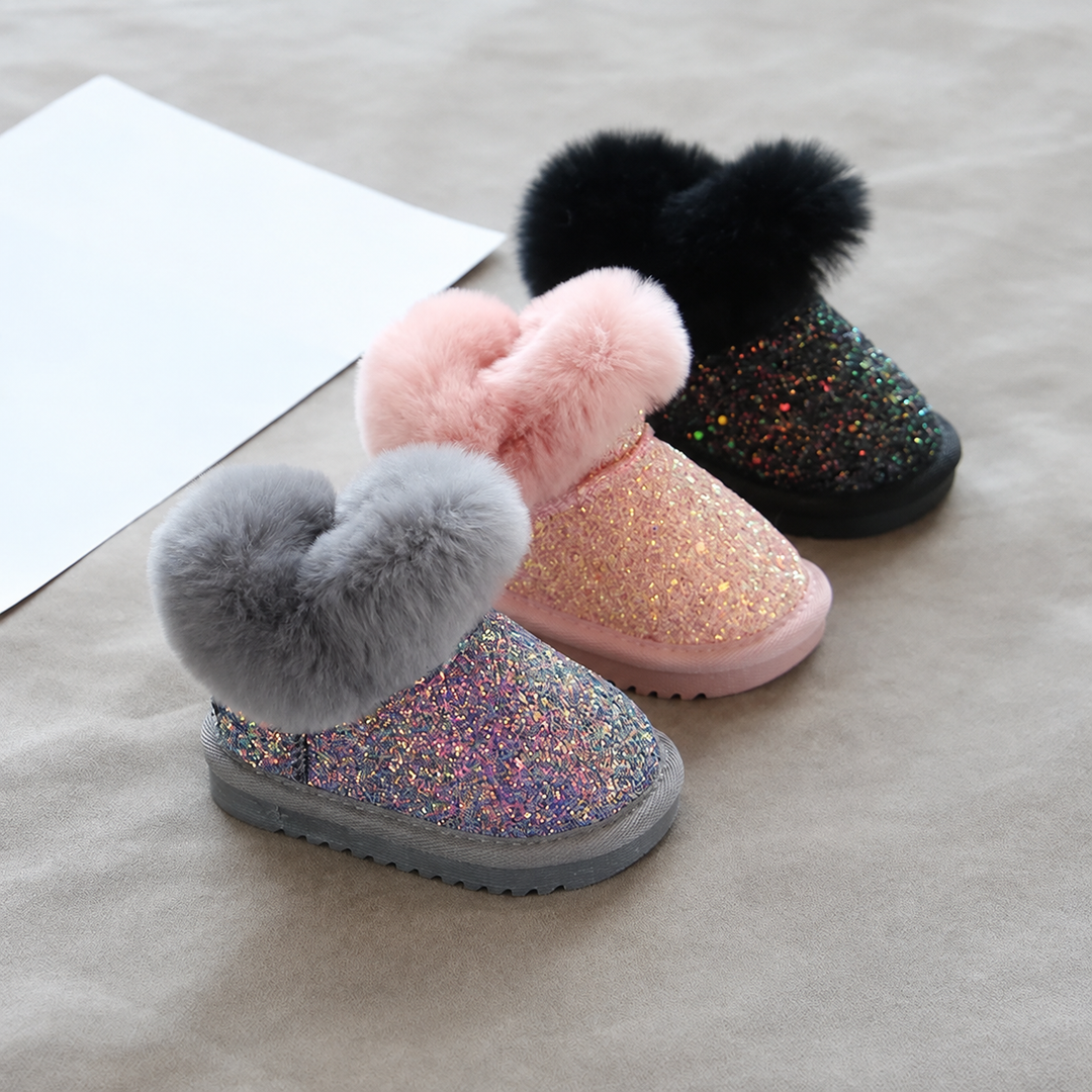 Gray, pink, and black glitter winter boots arranged on a gray surface.