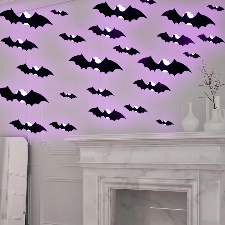 Black bat decorations with purple lighting above a white fireplace