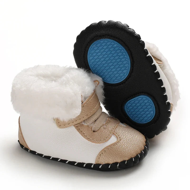 Gold and white baby winter boots with one sole turned up to show blue textured patches