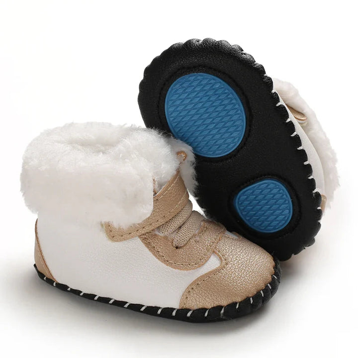 Gold and white baby winter boots with one sole turned up to show blue textured patches