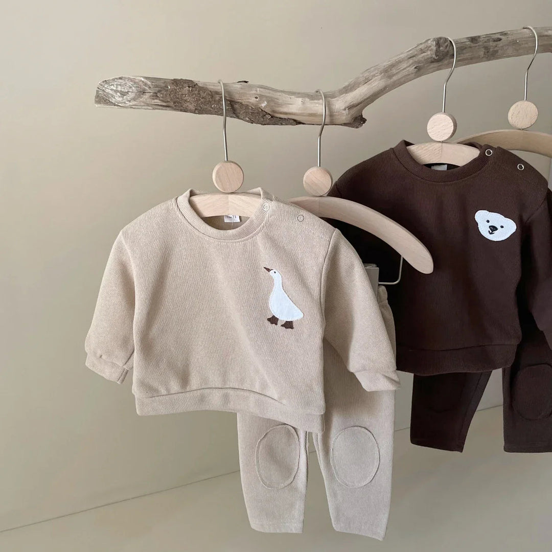 Beige goose and brown bear cotton tracksuits hanging side by side
