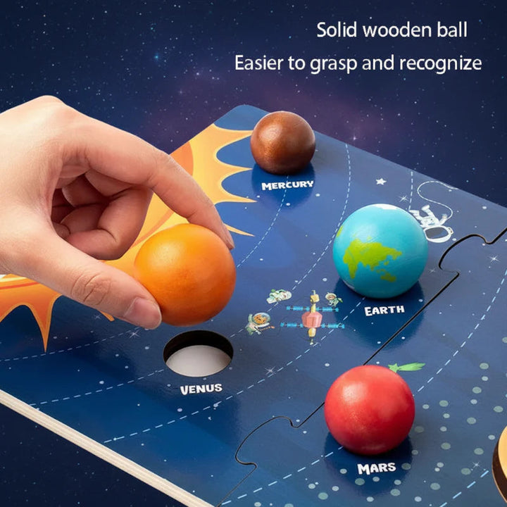 Hand lifting the orange Venus piece from a labeled wooden solar system board