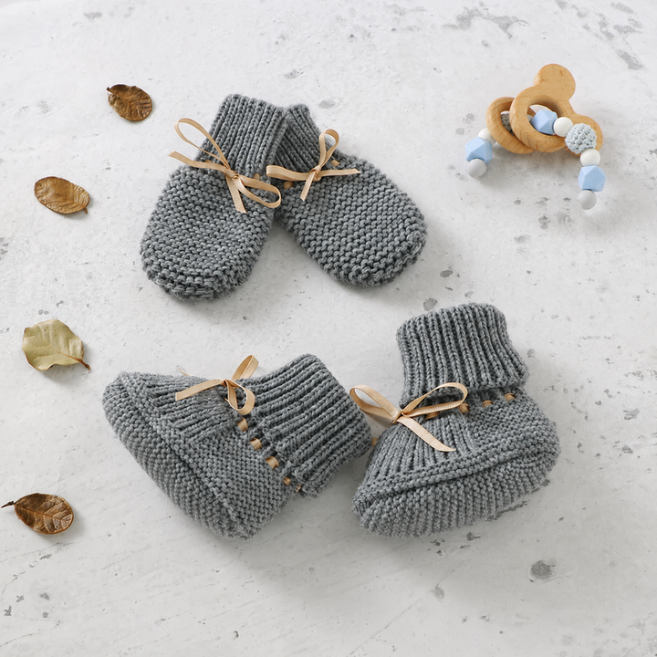 Gray knitted baby booties and matching mittens with ribbon ties