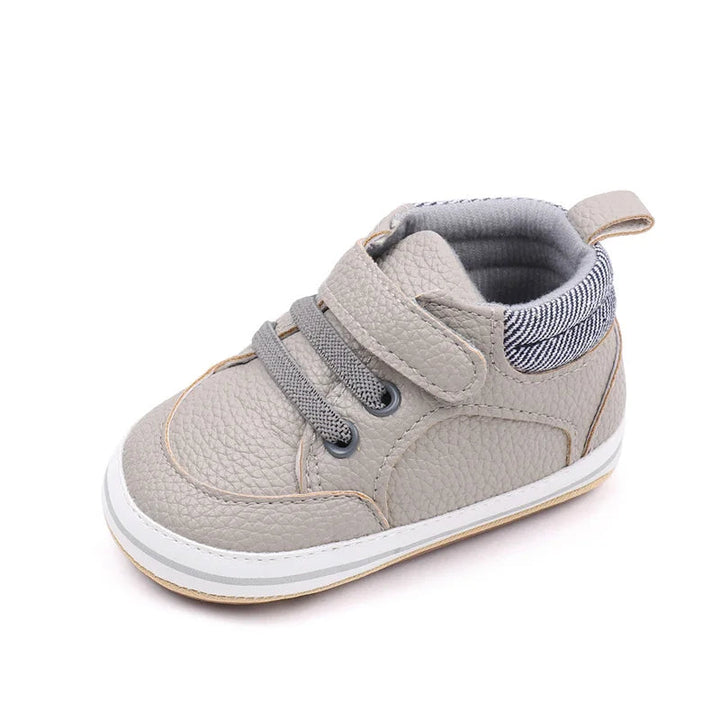 Gray baby sneaker with a hook-and-loop strap, lace detailing, and striped heel collar