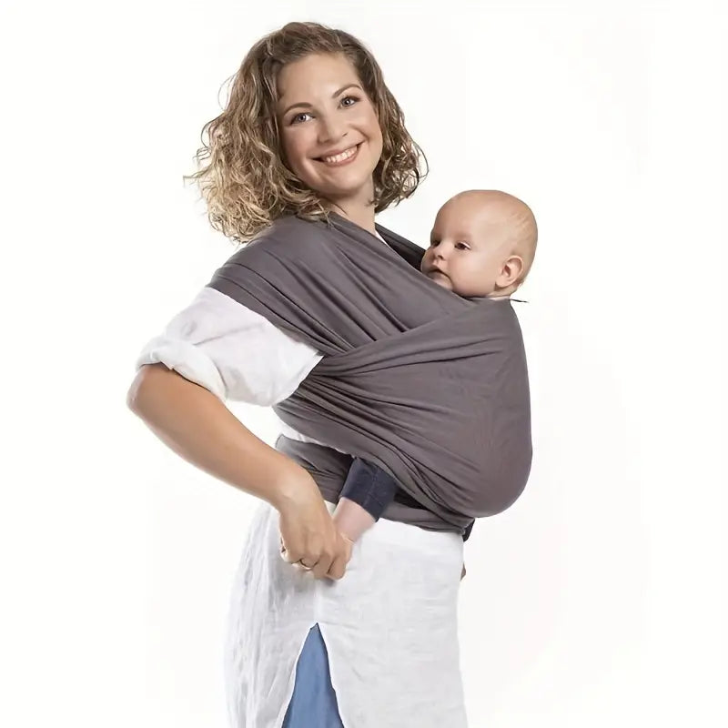 Parent wearing a gray baby wrap with a baby held close at the front