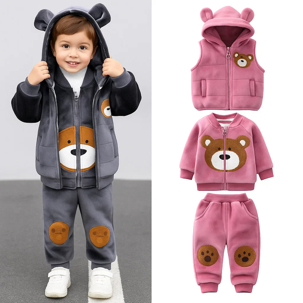 Child wearing a gray bear outfit beside a pink hooded vest, bear-face zip top, and paw-detail pants