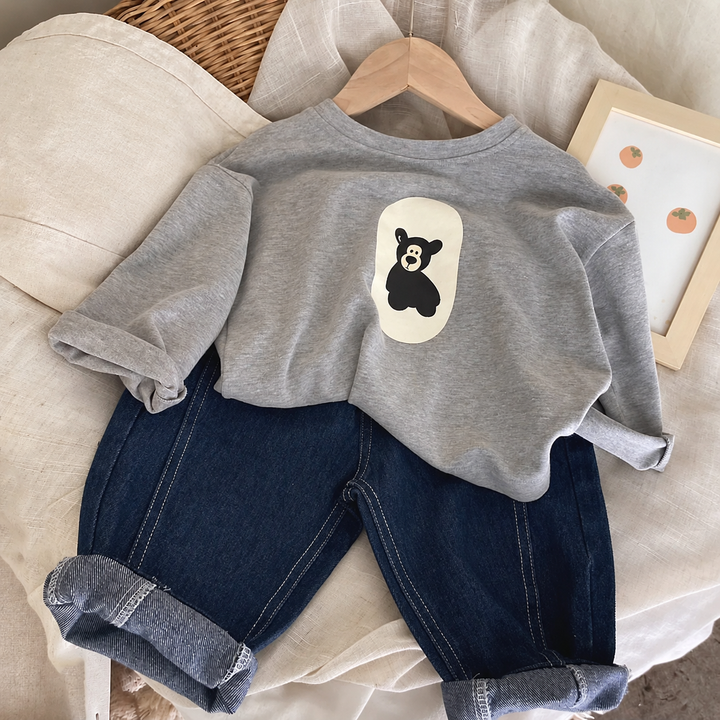Gray bear-print sweater styled with dark blue jeans