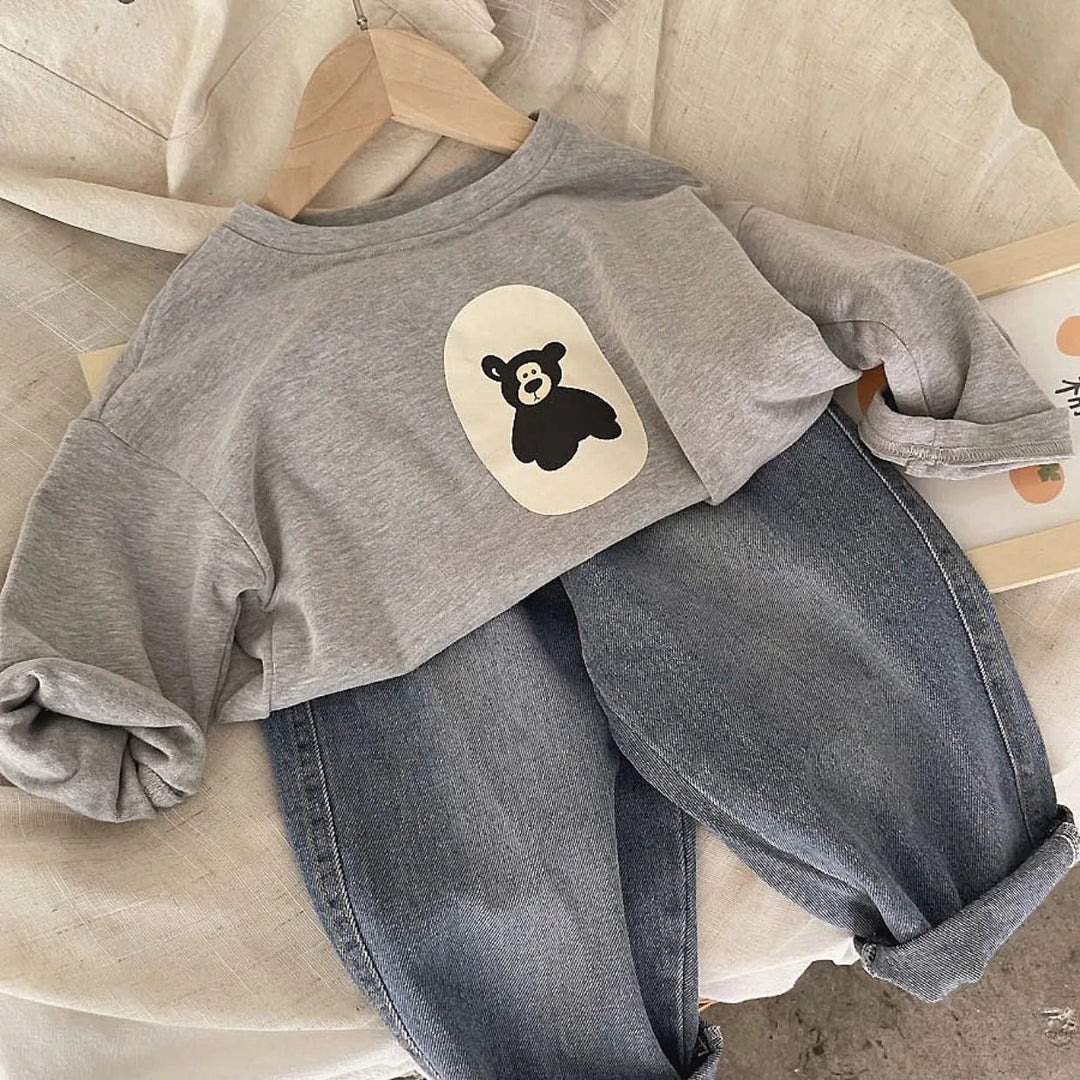 Gray bear-print sweater paired with washed gray jeans