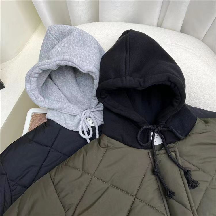 Close-up of gray and black hoods on blue and green quilted jackets.
