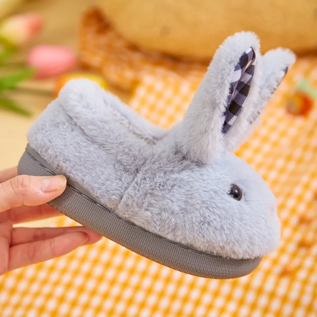 Side view of a gray bunny slipper showing its plush upper and flat sole