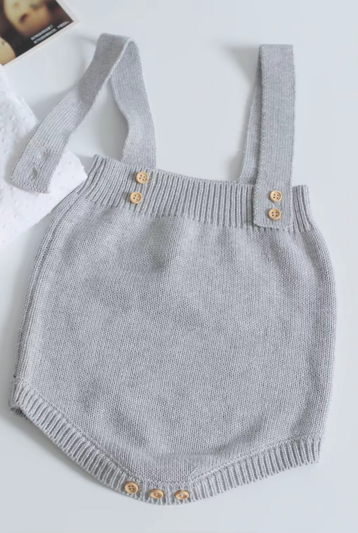 Light gray knit baby romper with ribbed edges and button fastenings