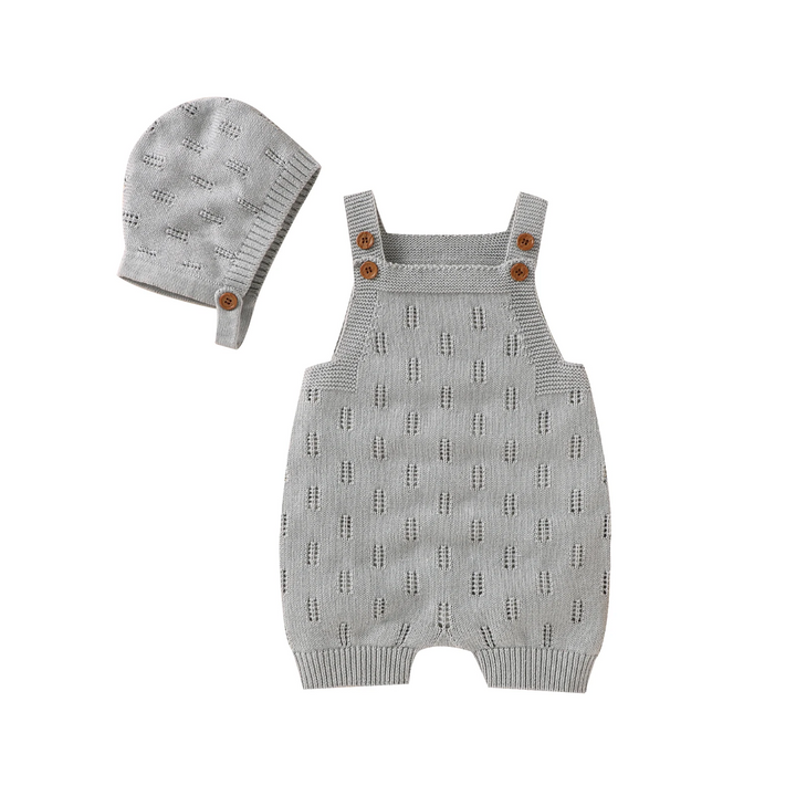 Gray knitted baby overalls with buttoned shoulder straps and a matching hat.