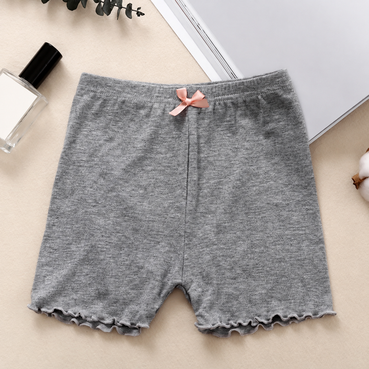 Gray cotton pajama shorts with an elastic waistband and pink bow, laid flat on a tabletop