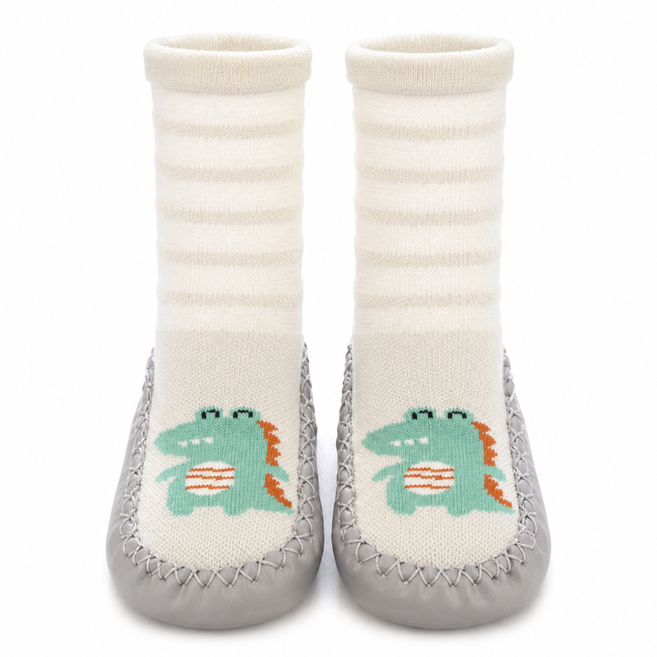 Sock shoes with white striped uppers, green dinosaur designs, and gray soles