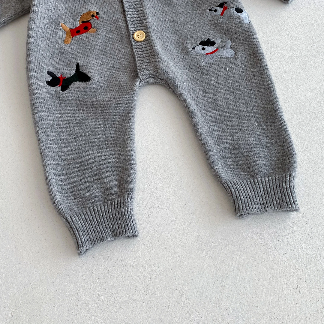 Gray baby jumpsuit showing dog motifs, full-length legs, and ribbed ankle cuffs