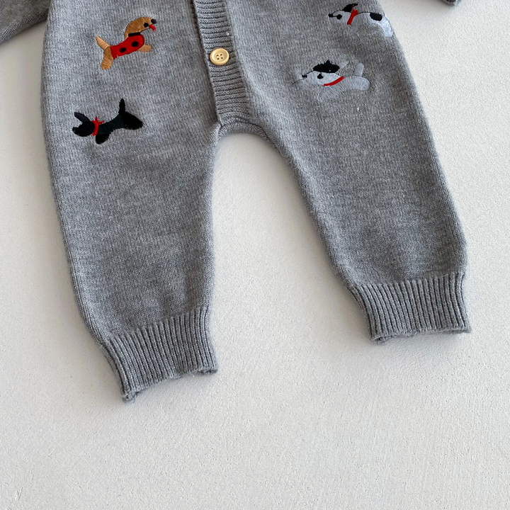 Gray baby jumpsuit showing dog motifs, full-length legs, and ribbed ankle cuffs