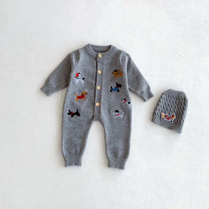 Gray dog-pattern knitted baby jumpsuit laid flat beside a gray knit hat