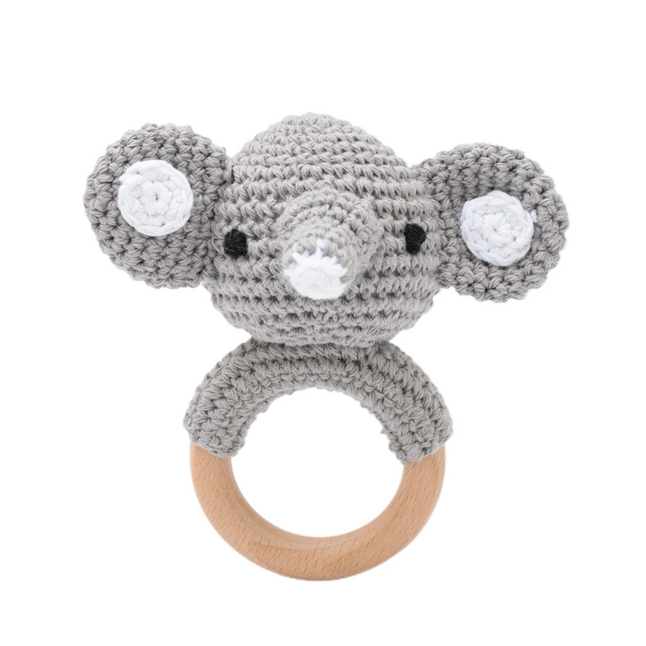 Gray crocheted elephant rattle with wide ears, pink cheeks, and a wooden ring